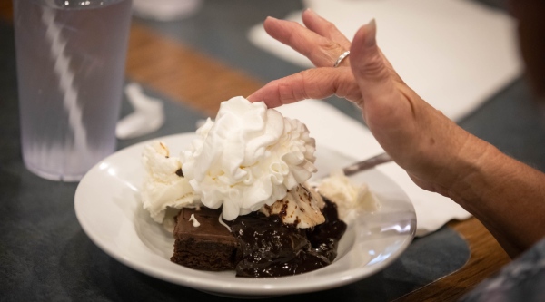 Ice cream on a brownie topped with whipped cream